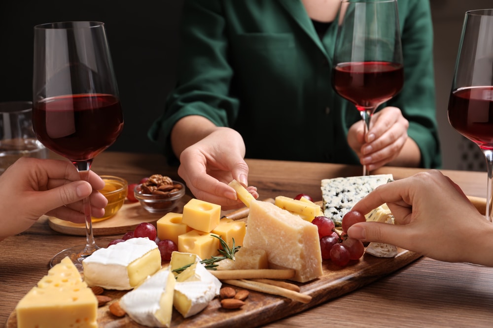 people enjoying wine and cheese, like the products you'll find at Widmer's Cheese Cellars in Wisconsin