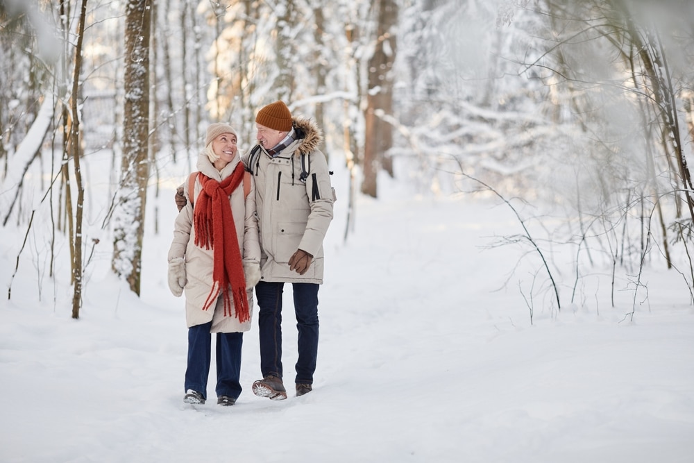 Couple walking through the woods in the snow during their romantic weekend getaway near Chicago at our Wisconsin Bed and Breakfast