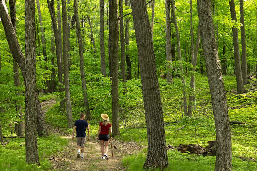 A couple enjoys a stunning nature trail on our property during a couples getaway in Wisconsin near Milwaukee.